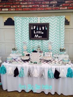 a little man baby shower party with chevrons and pom poms on the table