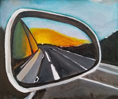 a car's side view mirror is shown with an orange sky in the background