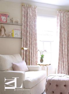 a living room with white furniture and pink curtains