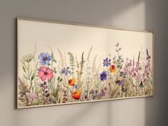 a painting hanging on the wall with flowers painted on it