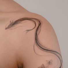 the back of a woman's shoulder with long hair and flowers on it,