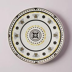 a white plate with black and yellow designs on the front, sitting on a gray surface