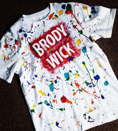 a white t - shirt with the words broddy wick on it and paint splatters all over it