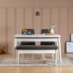 a white table with two chairs and a bench in front of it on top of a hard wood floor