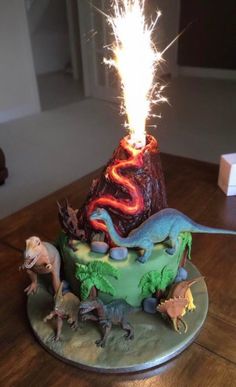 a birthday cake with dinosaurs on it and a sparkler in the air over top