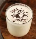 a glass filled with milk sitting on top of a wooden table