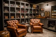 two leather chairs sitting in front of a wall full of liquor bottles and shelves filled with bottles