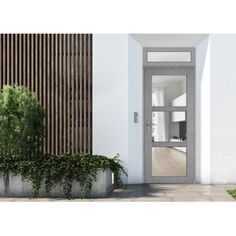 an open door to a white house with wood slats on the wall and planters