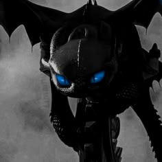 a black dragon with blue eyes standing in the dark