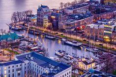 an aerial view of a city with boats in the water and buildings lit up at night