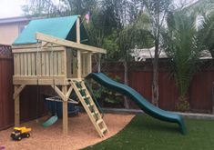 a wooden swing set and slide in a backyard