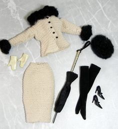 a crocheted doll outfit and accessories are laid out on a white surface,