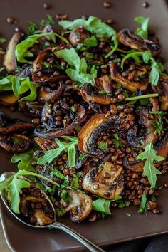 a plate filled with mushrooms and lentils on top of a table