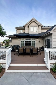 a house with white railings and wooden decking