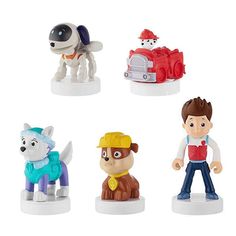 four small toy figurines of dogs and people on white bases, each with a fireman's hat