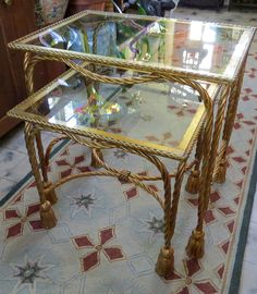 a glass table with gold trimmings on the top and bottom, sitting on a rug in a living room