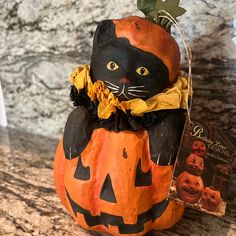 a black cat sitting on top of a pumpkin