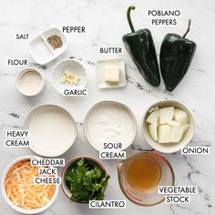 ingredients to make an entree laid out on a marble counter top, including carrots, cheese, sour cream, parmesan and broth