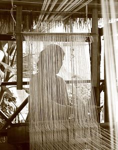 a man sitting in front of a weaving machine