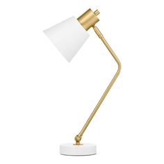 a gold and white desk lamp on a white base with a light shade over it