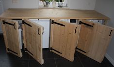 a kitchen with wooden doors opened to reveal the refrigerator and dishwasher in it