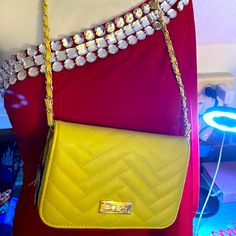 a yellow handbag is on display in front of a mannequin's torso