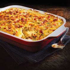 a red casserole dish with meat and cheese