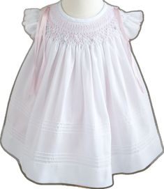 White Cotton Smocked Dress For Baptism, Spring Baptism Dress With Smocked Bodice, Spring Baptism Dress With Smock Detail, White Lace Trim Smocked Dress For Daywear, White Smocked Dress With Lace Trim For Daywear, Cotton Smocked Dress For Baptism, Fitted Smock Baptism Dress For Spring, White Fitted Smocked Dress For Baptism, Classic White Smocked Dress