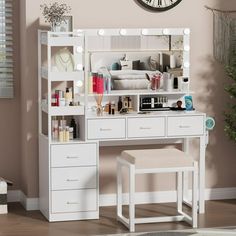 a white vanity with lights on it and a stool in front of the mirror is shown