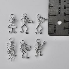 several metal charms with a measuring ruler in the background