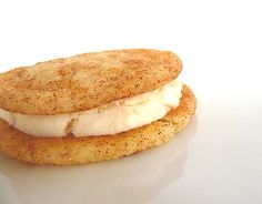 a biscuit sandwich with cream cheese on top is sitting on a white surface, ready to be eaten