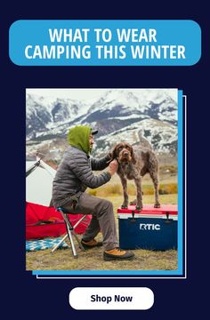 a man sitting in a chair petting a dog on top of a snow covered ground