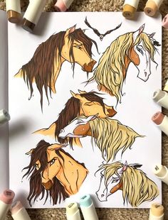 the horses are drawn on paper next to some crayons