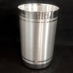 a metal cup sitting on top of a black table