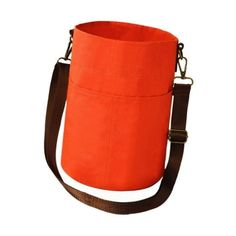 an orange tote bag with brown straps on the bottom, and one strap hanging down