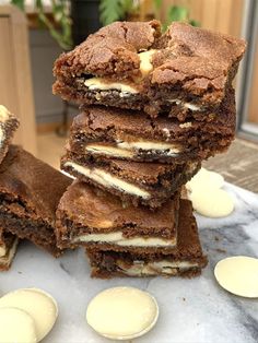 a stack of brownies sitting on top of a table next to some ice cream