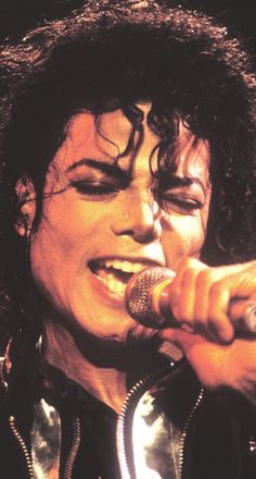 michael jackson singing into a microphone on stage