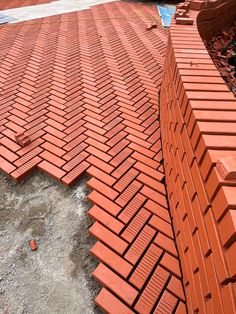 an orange brick laying on top of a pile of dirt next to a building under construction