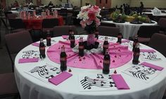 a table set up with pink napkins and wine bottles