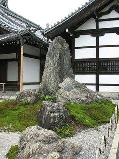 rocks and grass in front of a building