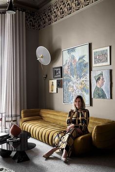 a woman sitting on top of a couch in a living room