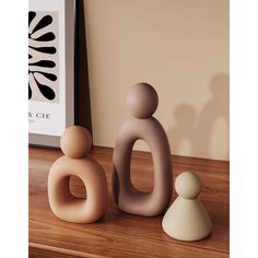 two ceramic figurines sitting on top of a wooden table next to a framed photograph