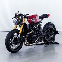 a red and white motorcycle parked on top of a metal stand