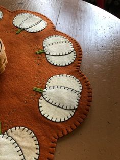 an orange rug with white circles on it and a basket next to it, sitting on top of a wooden table