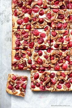 the dessert is made with nuts and cherries on top of white frosted squares