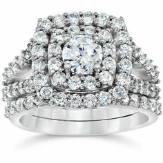 a white gold ring with two rows of diamonds on the band and an oval center surrounded by smaller round brilliant cut diamonds