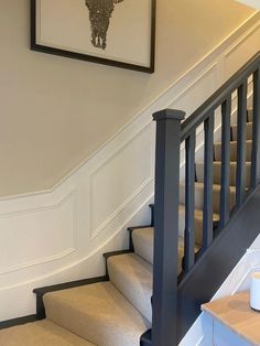 there is a painting on the wall above the stairs in this house that has been painted white