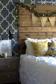 a bedroom decorated for christmas with garland on the headboard and lights hanging above it