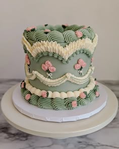 a three tiered cake decorated with flowers on a white plate next to a marble counter top