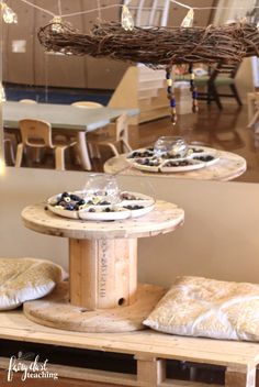 two round wooden tables topped with pastries on top of each other in a room